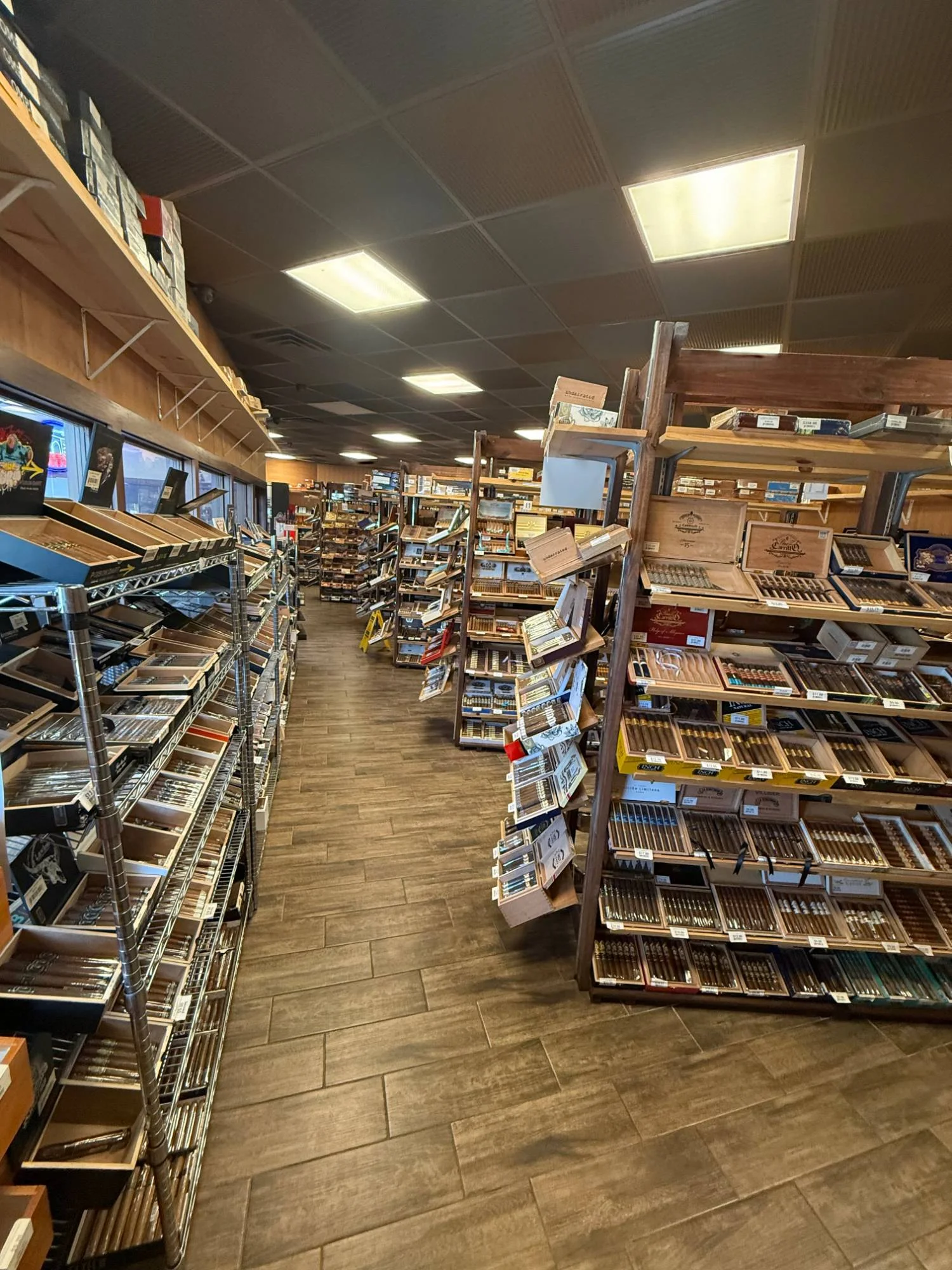 The front of the Cigar Heaven humidor — wire racks along the windows and wooden shelving stacked with cigar boxes.