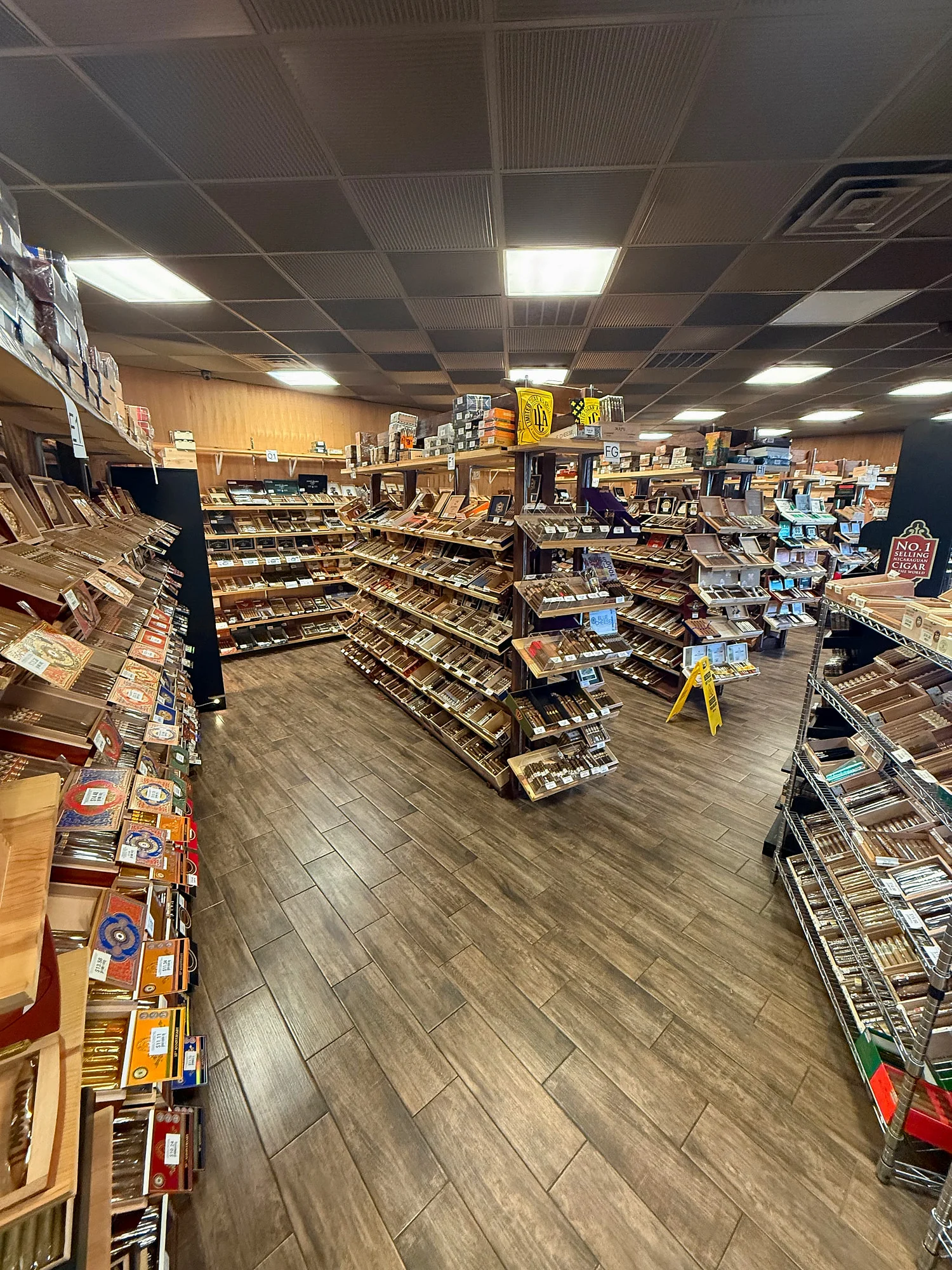Center racks and wall shelving across the Cigar Heaven humidor, stocked with boxes from dozens of brands.