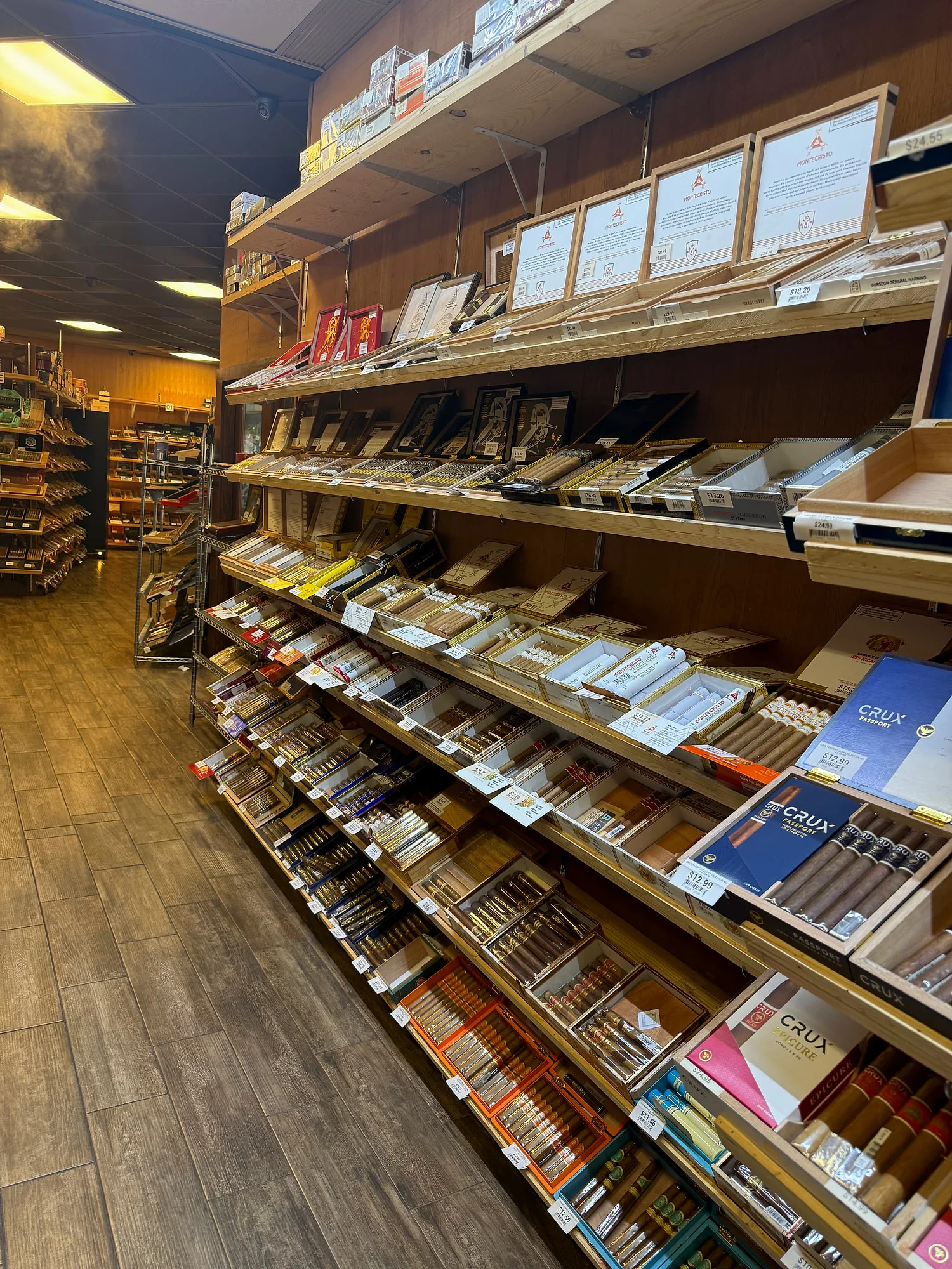 Montecristo, Crux and other boxes on long angled shelves in the Cigar Heaven humidor.