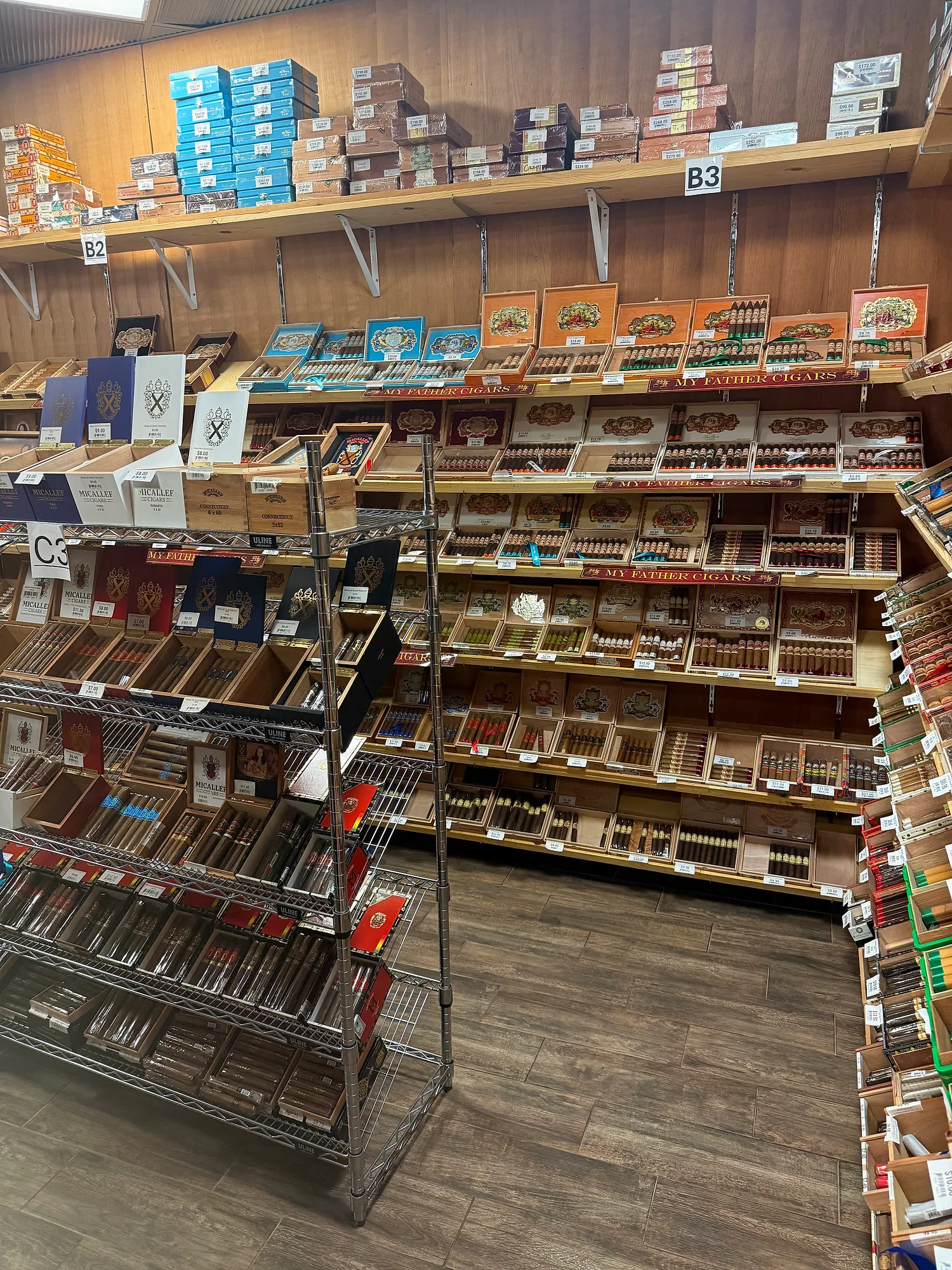 My Father cigars filling a wall of the Cigar Heaven humidor, with a rack of Micallef boxes in front.