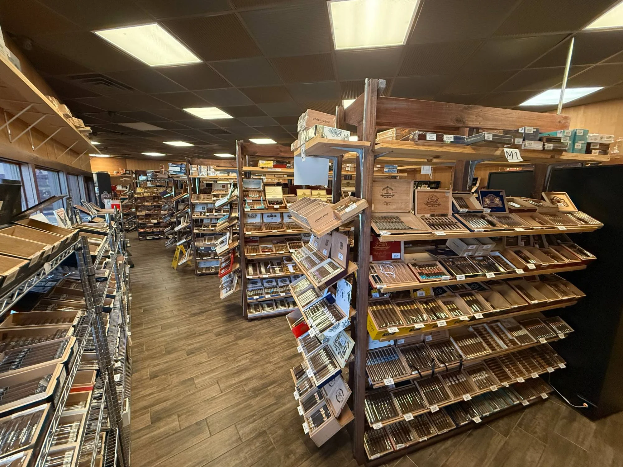 Wide view of the Cigar Heaven humidor floor — rows of wooden shelves holding hundreds of open cigar boxes.