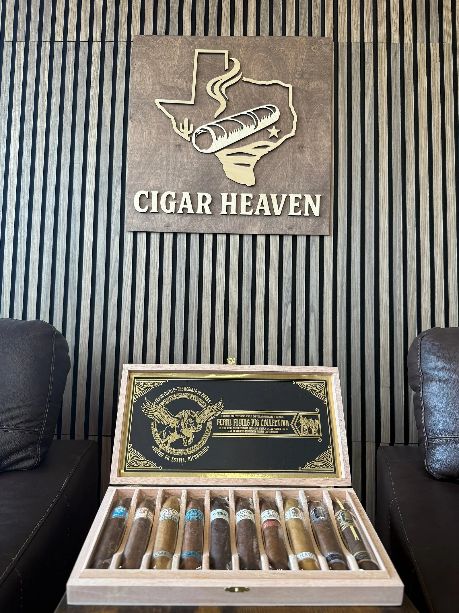 The open Drew Estate Feral Flying Pig Collection box with ten Feral Flying Pig perfectos, under the Cigar Heaven sign in the lounge.