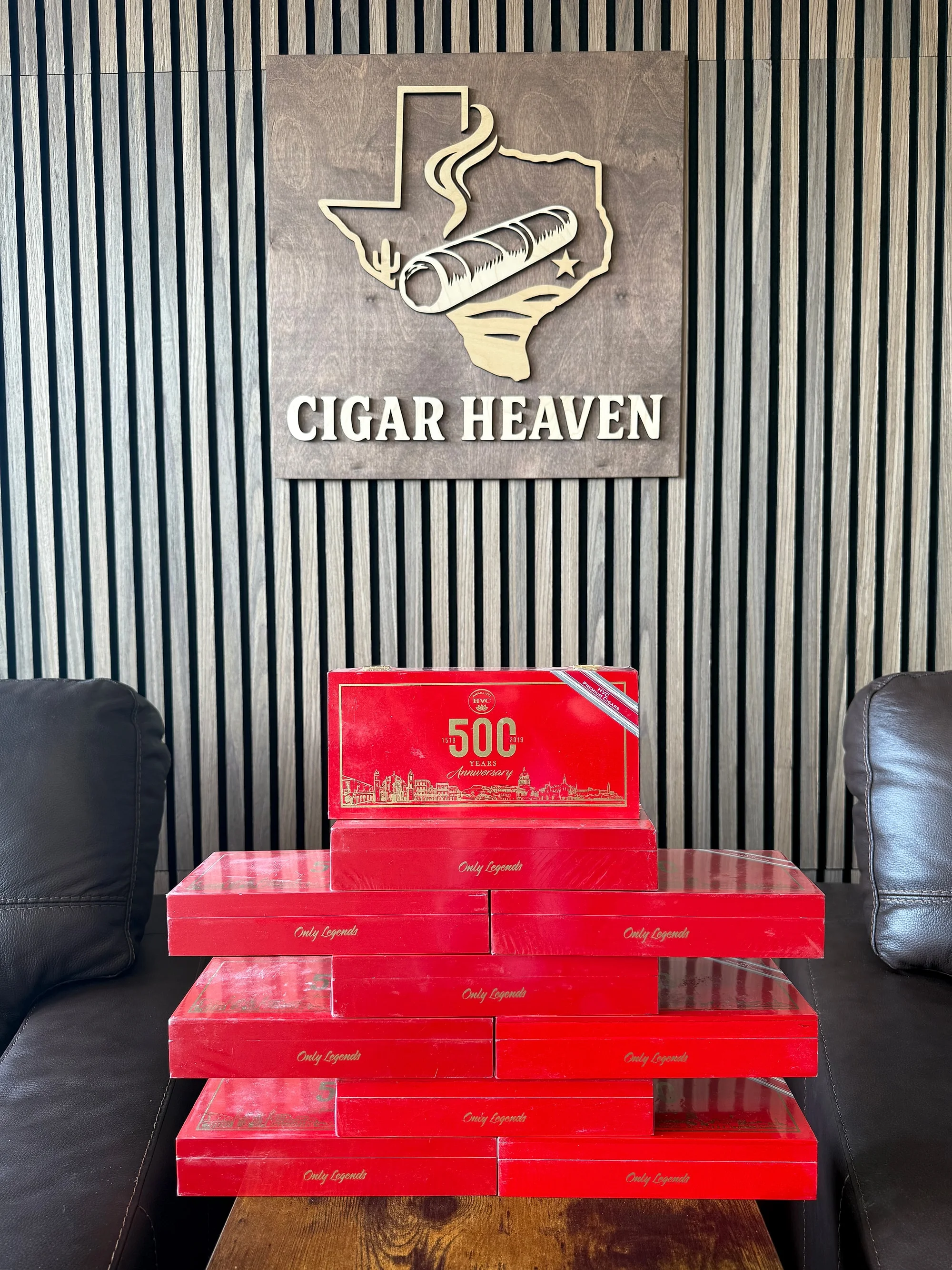 A stack of red HVC 500 Years Anniversary boxes marked Only Legends, under the Cigar Heaven sign in the lounge.